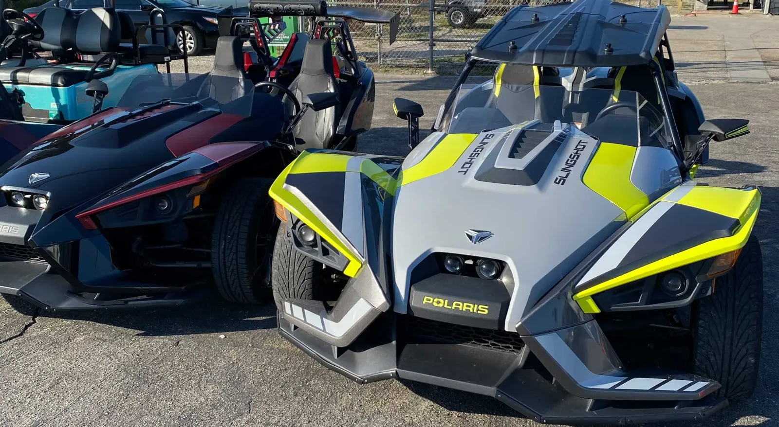 Gray and yellow Polaris Slingshot next to a maroon Slingshot in Panama City Beach