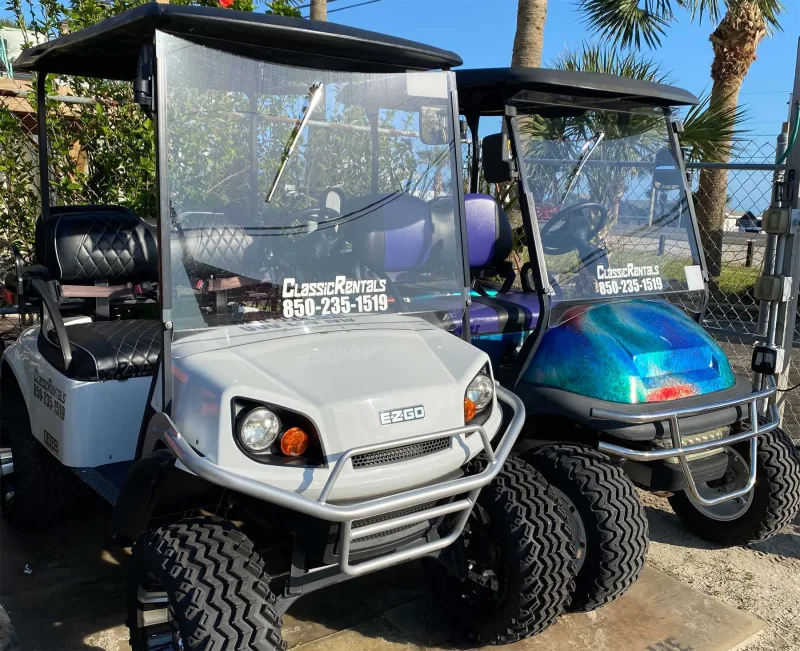 White and metallic teal golf carts for rent at Classic Rentals